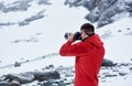 Young man taking picture in winter mountains. Royalty Free Stock Photo