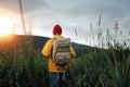 Back view of man tourist with backpack standing in front of the mountain massif while journey by scandinavian