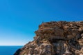 Back view of man traveler standing on mountain alone and looking at autumn sea landscape. Hiking in cold season.