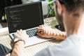 back view of man using laptop with html code