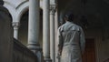 Man walking in hallway of old building. Businessman going in colonnade hallway Royalty Free Stock Photo