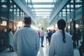 back view of a man and a woman scientists or doctors in white coats in the glass corridor of the science center Royalty Free Stock Photo