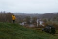 Back view of the man in a yellow jacket standing on top of the mount. off-road vehicle. Old car for extreme hobbies and recreation Royalty Free Stock Photo