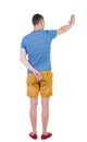Back view of man. Young man in shorts presses down on something