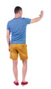 Back view of man. Young man in shorts presses down on something