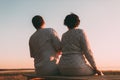 Back view a married couple a silhouette sitting on a bench. Royalty Free Stock Photo