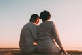 Back view a married couple a silhouette sitting on a bench. Royalty Free Stock Photo