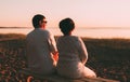Back view a married couple a silhouette sitting on a bench. Royalty Free Stock Photo