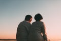 Back view a married couple a silhouette sitting on a bench. Royalty Free Stock Photo