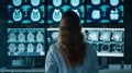 Back view of medical expert deciphering complex body scans on multiple digital displays in lab