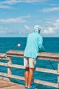 African-American, teenager fishing, off a wood dock in the waters of the gulf of Mexico Royalty Free Stock Photo