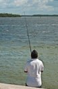 Hispanic male fishing at a bridge on backwaters of tropical, gulf of mexico