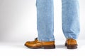 Back View of Mens Legs in Brown Oxford Brogue Shoes. Posing in Blue Jeans Against White Background Royalty Free Stock Photo