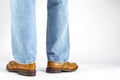 Back View of Mens Legs in Brown Oxford Brogue Shoes. Posing in Blue Jeans Against White Background Royalty Free Stock Photo