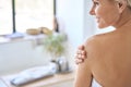 Back view of mid age woman applying body scrub. Anti age skincare concept. Royalty Free Stock Photo