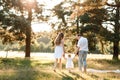 Back view of mother, father hold hands daughter enjoy nature and walk in the summer park. Young family spending time together on Royalty Free Stock Photo