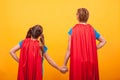 Back view of mother and her little girl dressed like superheros holding hands. Royalty Free Stock Photo