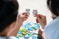 Back view of mother and son lying on the floor holding puzzle pieces and putting them together. Happy family during work at home. Royalty Free Stock Photo