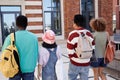 Back view of multiethnic group of young students walking in row outdoors Royalty Free Stock Photo