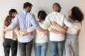 Back view of happy international young people stand hugging Royalty Free Stock Photo