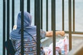 Back view of Muslim woman relax and admire the beautiful scenery in the evening on The Bridge of the River Kwai in Kanchanaburi,