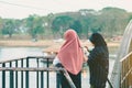 Back view of Muslim women relax and admire the beautiful scenery in the evening on The Bridge of the River Kwai in Kanchanaburi,