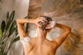 Back view of naked young woman washing her hair while taking shower in bathroom Royalty Free Stock Photo