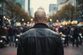 Back view of neo nazi with shaved heads and leather jacket in city street with blurry people