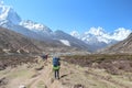 Nepalese sherpa porter walks carrying heavy bags in Himalayas
