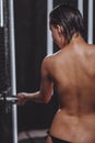 Back view of nude woman with drops on her smooth skin in douche bath Royalty Free Stock Photo