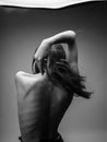 Back view of nude woman with loose hair in black and white photograph Royalty Free Stock Photo
