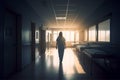 Back view of nurse walking through empty hospital corridor