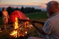 Old man playing guitar in camp. Royalty Free Stock Photo