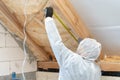 Workman in overalls working with rockwool insulation material