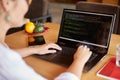 Back view over the shoulder shot of developer programmer with laptop. Program code and script data on the screen. Young Royalty Free Stock Photo