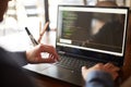 Back view over the shoulder shot of developer programmer with laptop. Program code and script data on the screen. Young Royalty Free Stock Photo