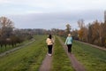 Back view of a pair of female friends walking in a park in the morning