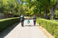 Back view of parents with child walking in the park. Targoviste, Romania, 2019