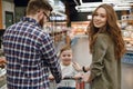 Back view of parents pushing shopping trolley Royalty Free Stock Photo