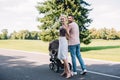 back view of parents walking with baby carriage on road in park mother Royalty Free Stock Photo