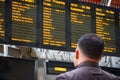 Back view of a passenger checking train timetable