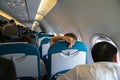 Back view of passenger traveler in airplane, travel by flight, man tourist sitting in air plane