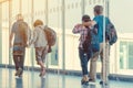 Back view of passengers and traveling luggage walking the airplane boarding corridor from the terminal