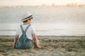 Back view of a Pensive child sitting on the beach Royalty Free Stock Photo