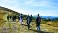 Back view of people hiking the mountains. Group of people hiking forward the pass. Group of hikers walking