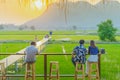 Back view of people sit for resting and waiting for time to take photos of the sunset on the farmer`s balcony