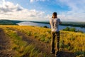 Back view of a photographer taking pictures of river landscape