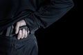 Back view of pistol being pull out of pants by male hand Royalty Free Stock Photo