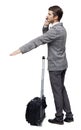 Back view of pointing business man with suitcase talking on the phone Royalty Free Stock Photo