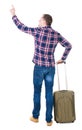 Back view of pointing man with suitcase.